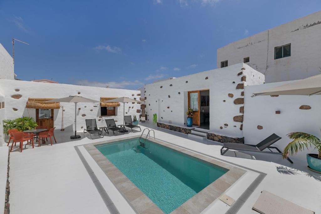 a swimming pool in front of a building at Arrieta Costa Rural in Tabayesco