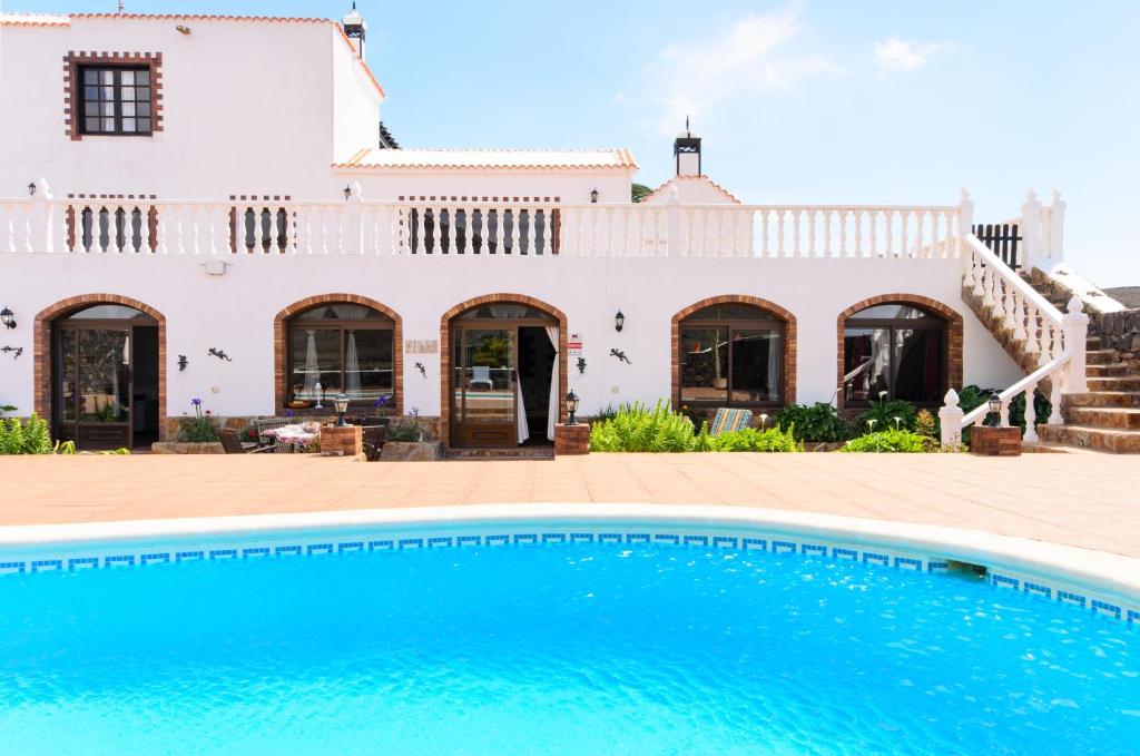a villa with a swimming pool in front of a house at Clara Suite 2 - Macaronesiahomes in Masdache