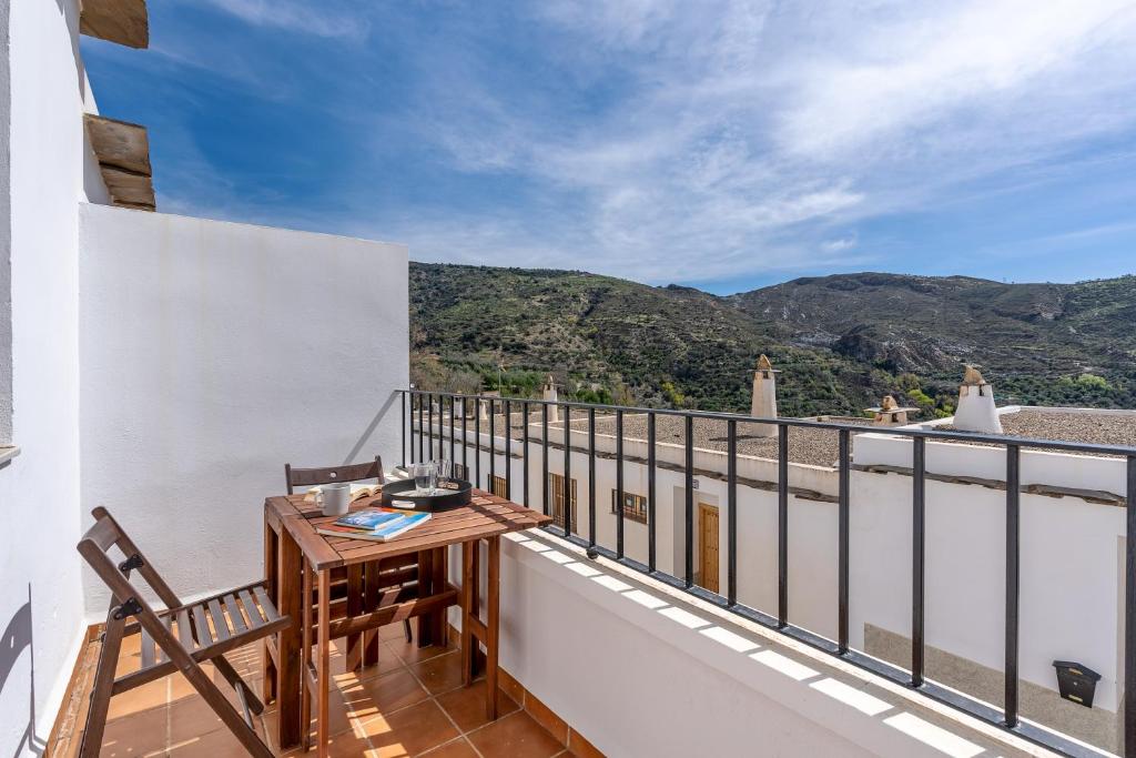 a balcony with a table and chairs and mountains at Villa picena las alpujarras in Picena