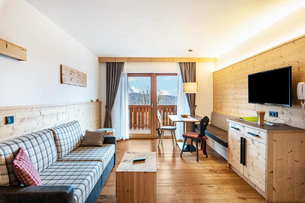 a living room with a couch and a tv at Hatzes App Schlern in Laion