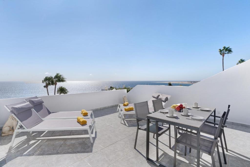 a patio with a table and chairs and the ocean at Bungalow Seaview in San Bartolomé
