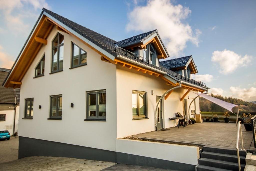 a house with a large deck on the side of it at Ferienwohnung Stratmann in Lennestadt