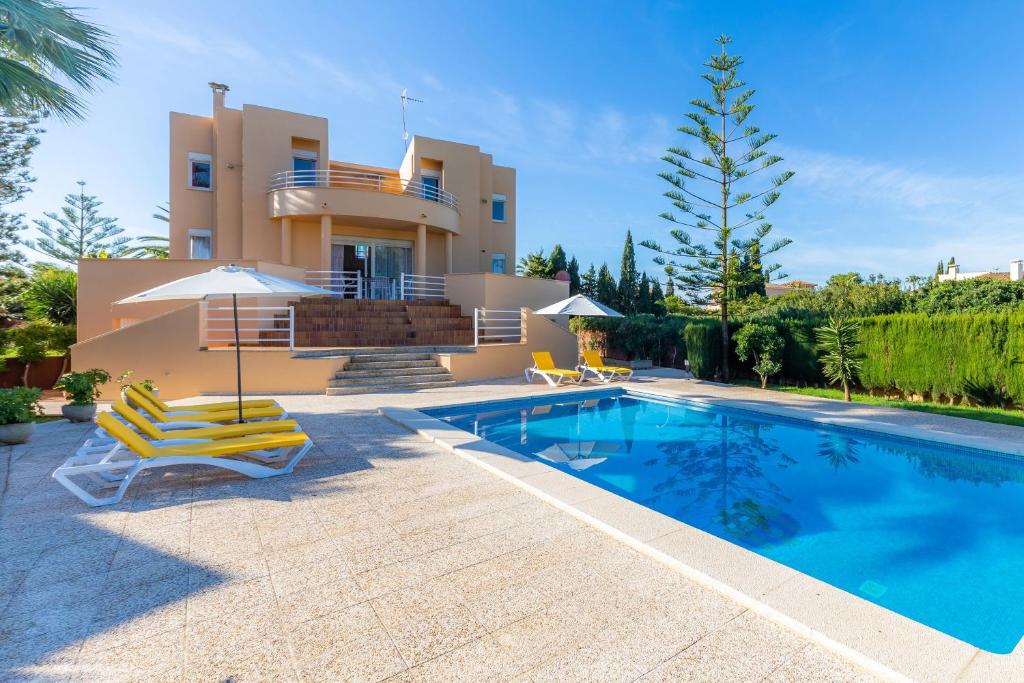 a villa with a swimming pool in front of a house at Ca Na Xisca in Sa Coma