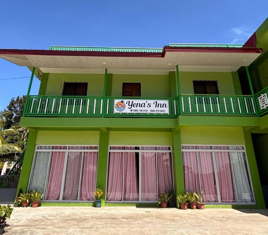 a green building with a sign on it at Yena's Inn in Cauayan