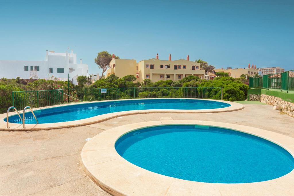a large swimming pool with blue water at Los Delfines Biniforcat in Ciutadella