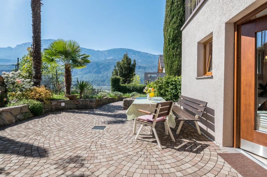 a patio with a table and a table and chairs at Haus Rosengarten Apt A in Terlano