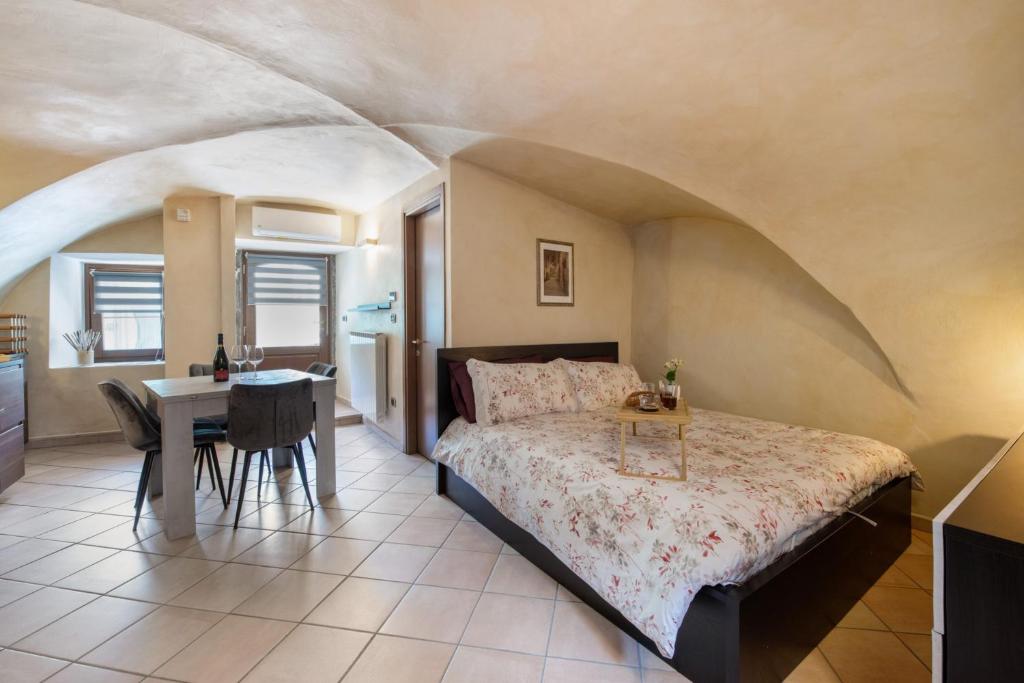 a bedroom with a bed and a table and a desk at Le Volte - Lago D'Iseo in Pisogne