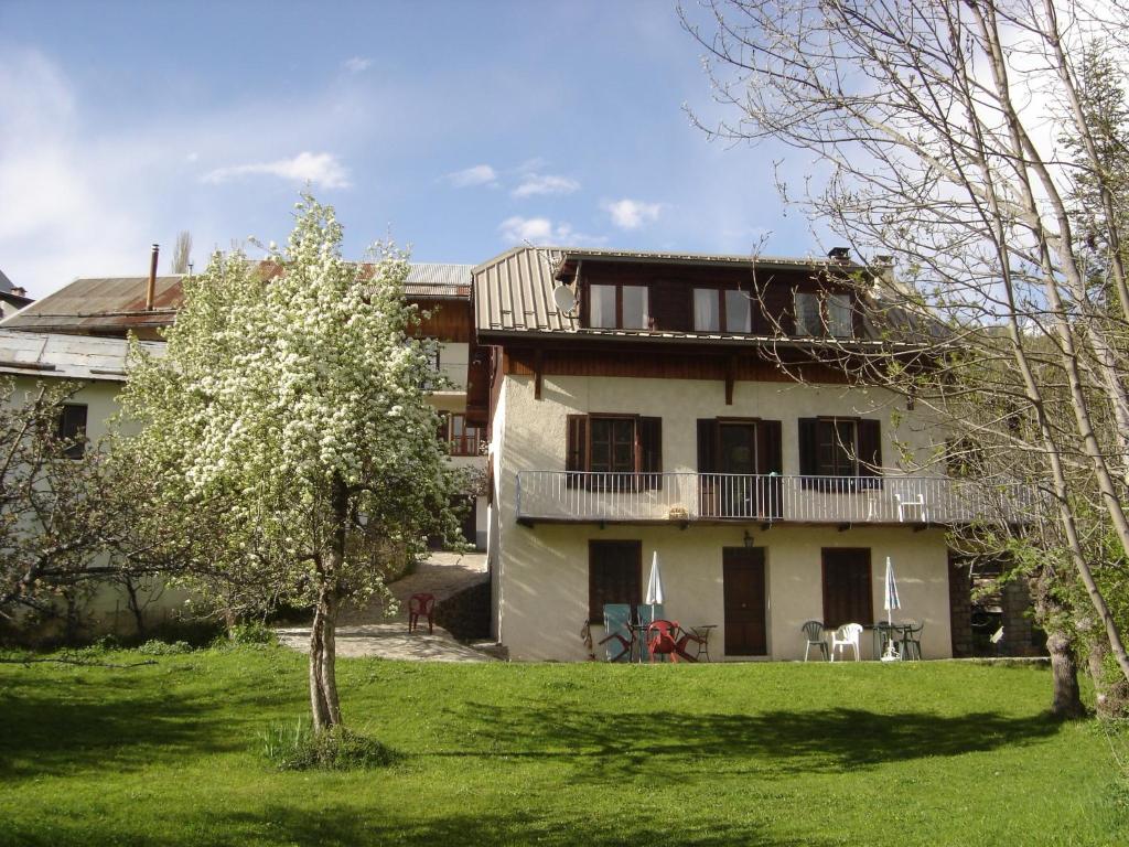 a large house with a balcony and a yard at Appartement la Cascade in Allos