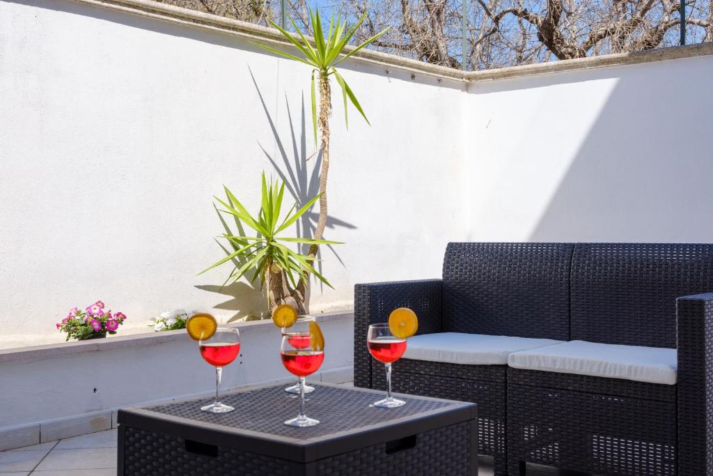 two glasses of red wine on a table on a patio at Casa Angel in Galatone