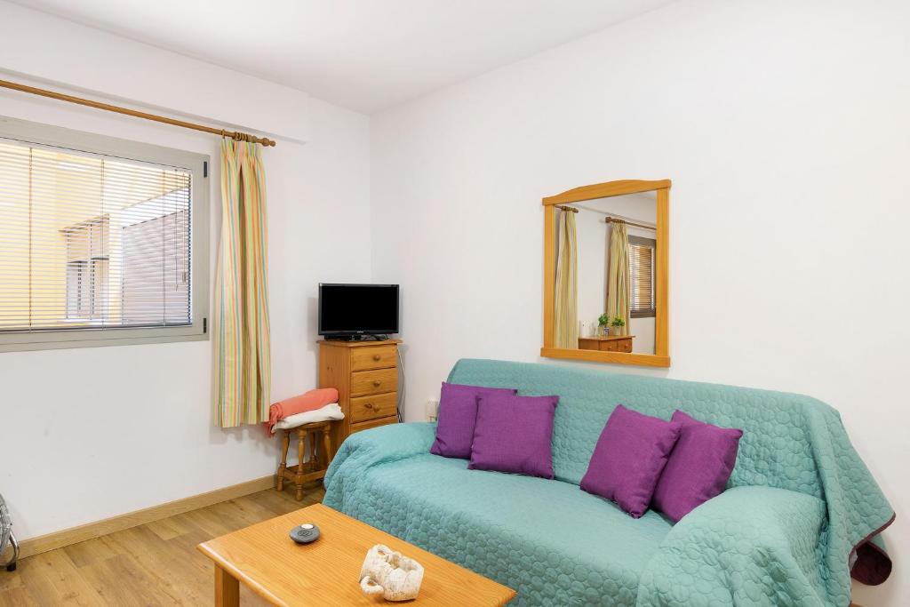 a living room with a green couch and a mirror at Piso tazacorte in Tazacorte