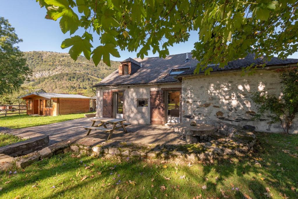 a stone house with a picnic table in front of it at Charmante Bergerie in Castet