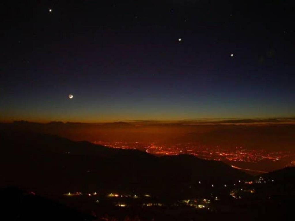 a view of a city at night with the moon and stars at Appart 7 Laux - Balcon Sud in Les Adrets
