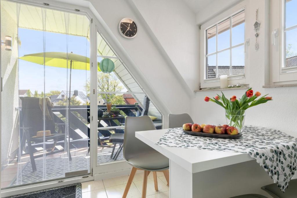 a kitchen with a table and chairs and a balcony at Gertruds Leuchtturm Strandnah in Zingst