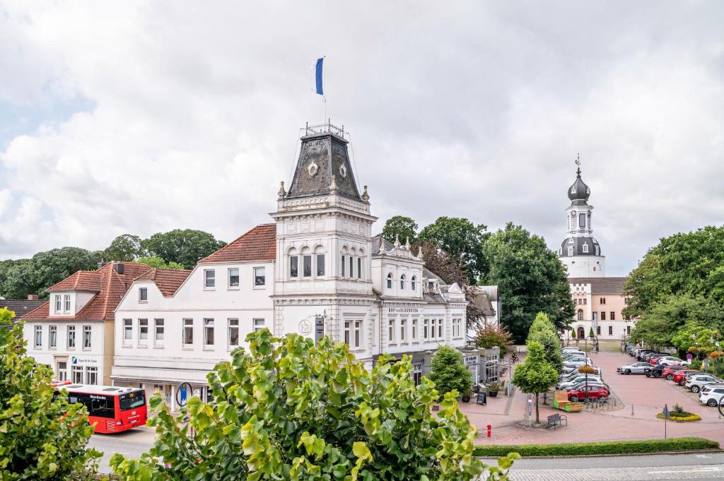 a large white building with a tower on a street at Altstadtblick Jever in Jever