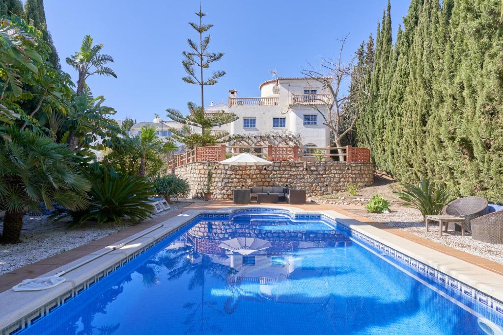 a swimming pool with a house in the background at Casa Alba in Salobreña