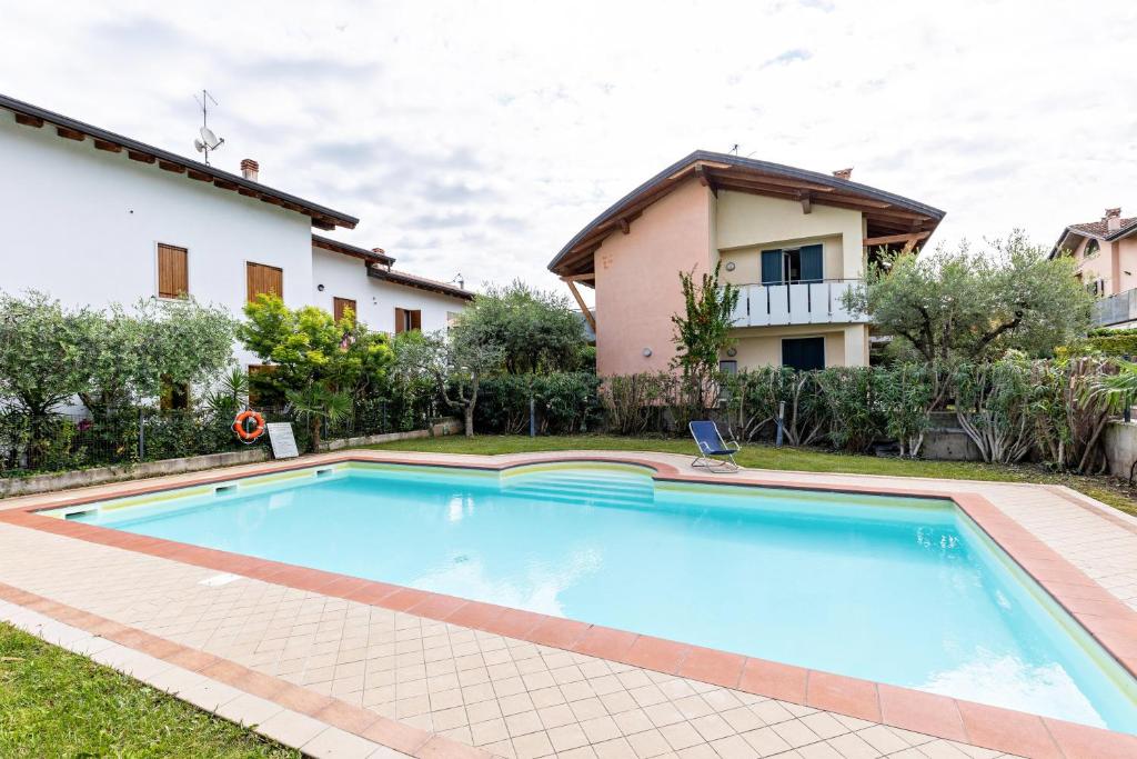 a swimming pool in front of a house at Bluemoon Luminoso apt con piscina in Lazise