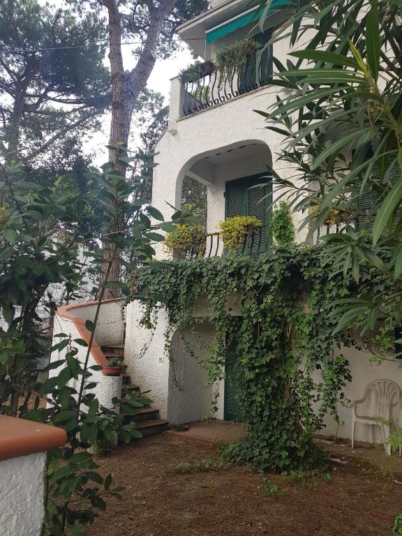 a white house with ivy growing on the side of it at Villa Su 3 Piani Con Giardino in Lido di Spina