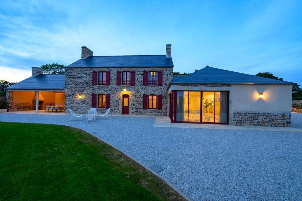 a large stone house with a driveway in front of it at Domaine le St Georges - Piscine in Saint-Sauveur-le-Vicomte