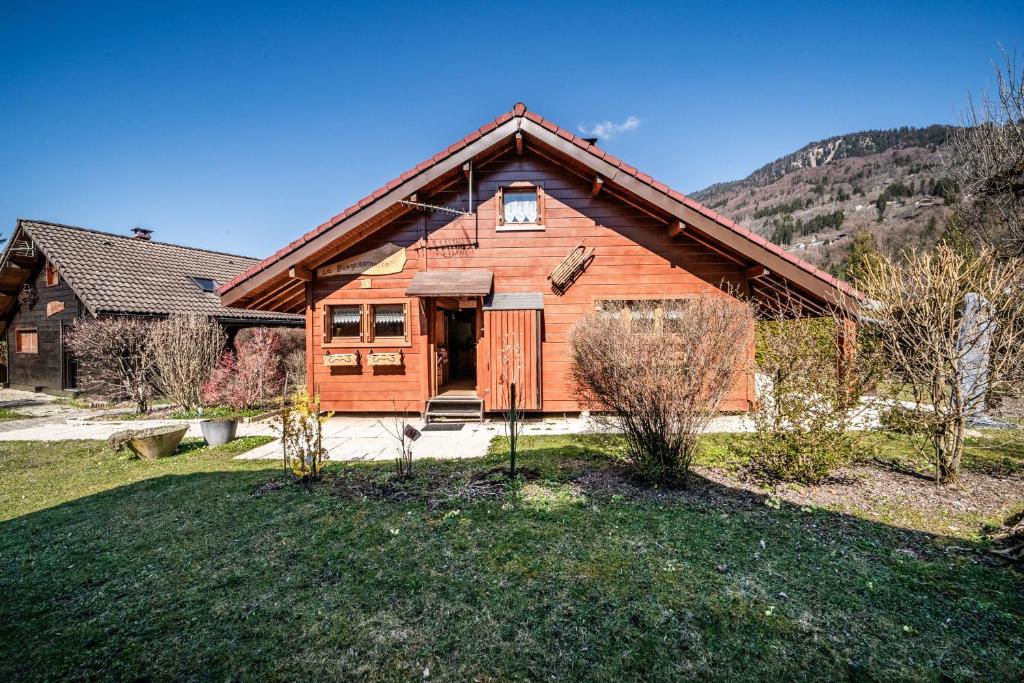 a large wooden house with a grass yard at Chalet 6p Premium - La Bergeronette in Verchaix