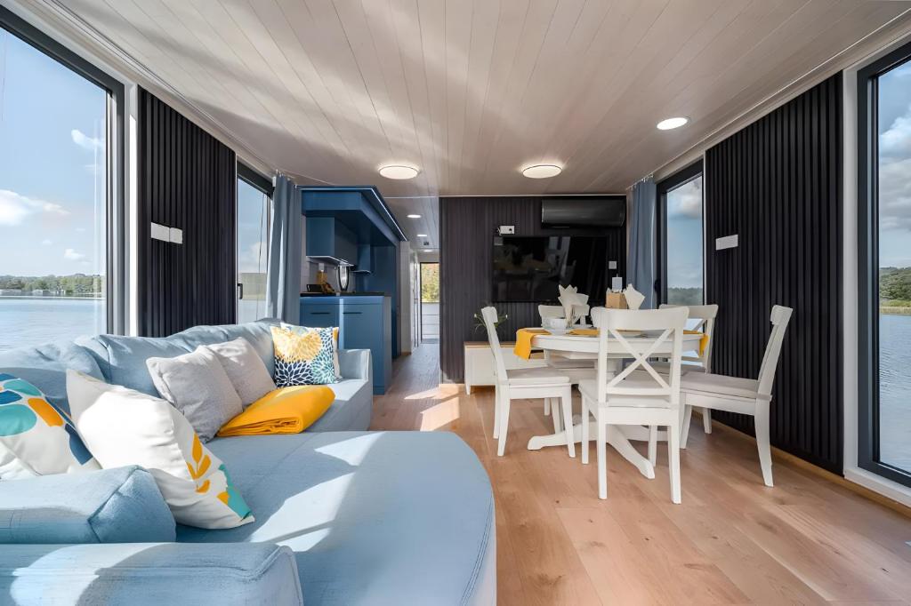 a living room with a couch and a table with chairs at Entspannung pur - Hausboot Liberty in Fürstenberg