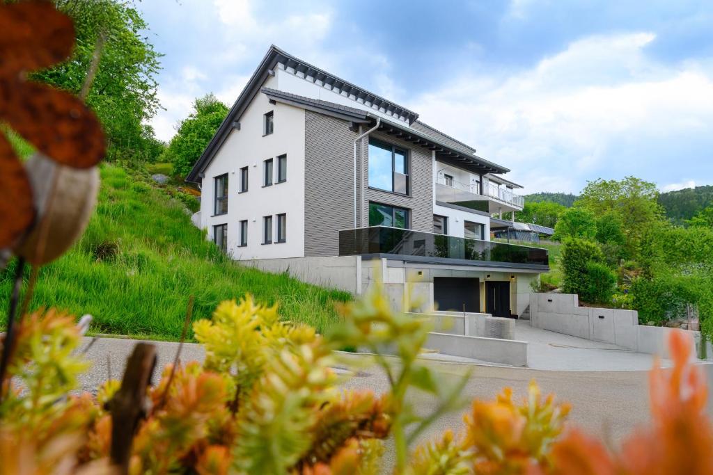 a house on the side of a hill with flowers at Ferienwohnung Talblick in Kappelrodeck