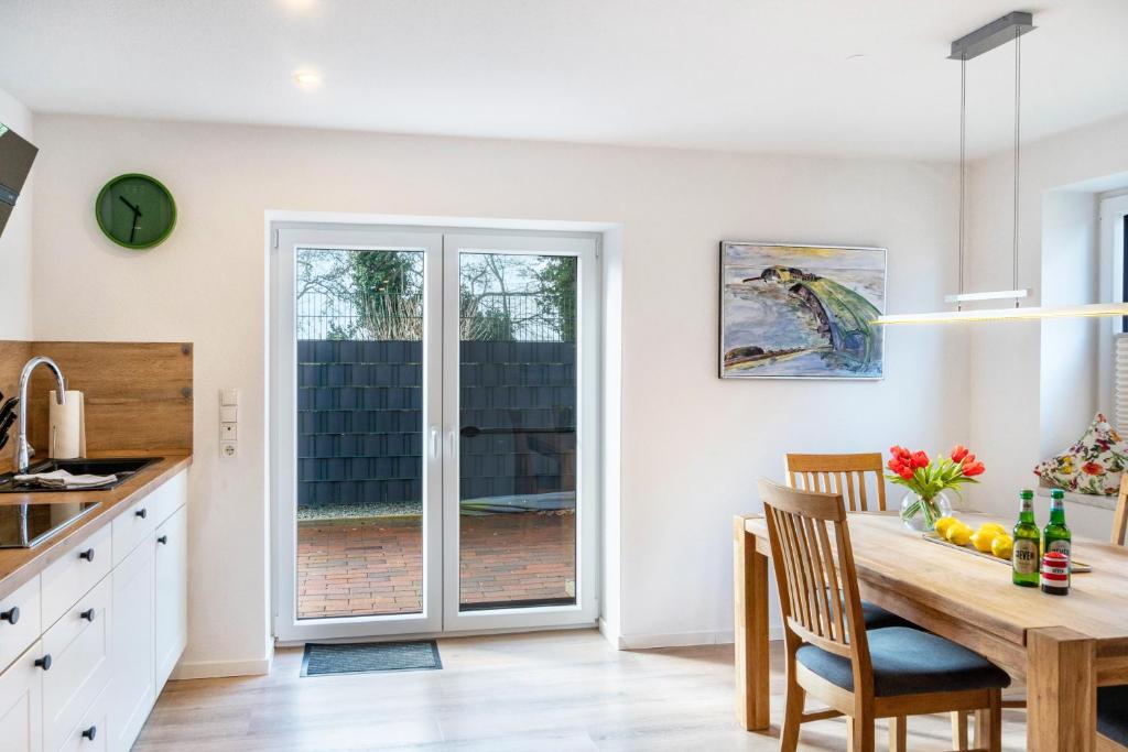 a kitchen and dining room with a table and chairs at Landhaus Gerda in Wangerland