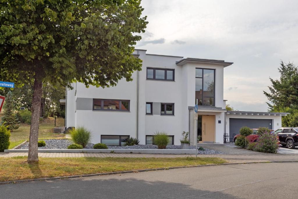 a white house with a car parked in front of it at Casa Simona in Orsingen-Nenzingen
