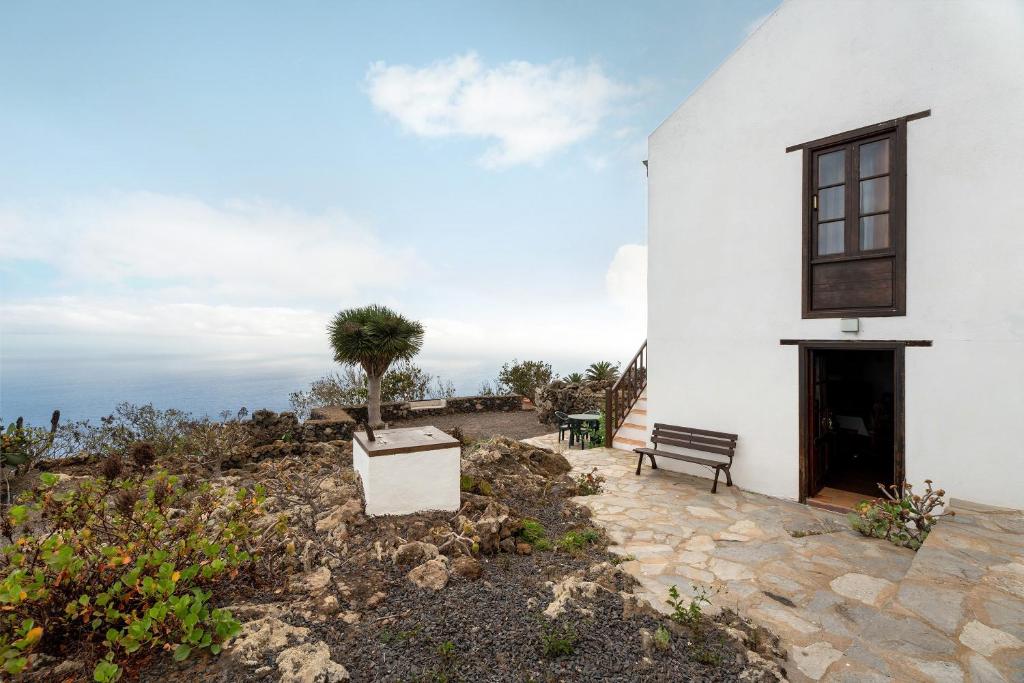 a white building with a bench and a tree at Casa Rural La Era in Valverde