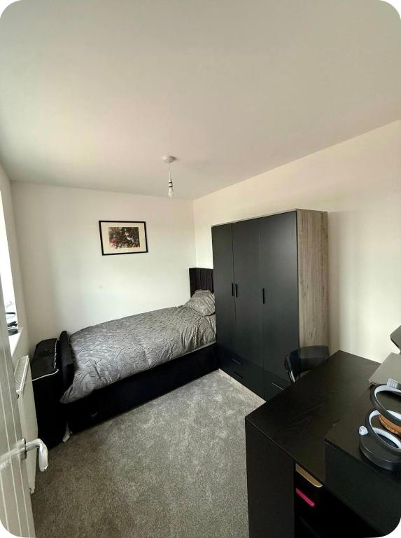 a bedroom with a bed and a black cabinet at Single room in Tamworth in Wigginton