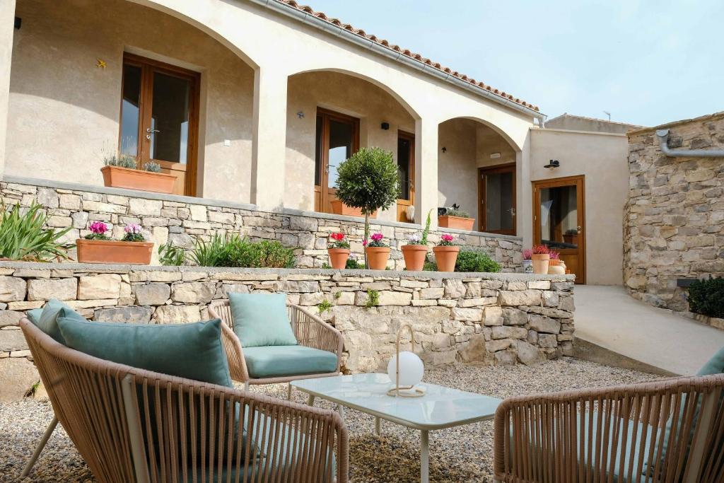 a patio with a table and chairs and a stone wall at Casa Comalats in Montoliu de Segarra