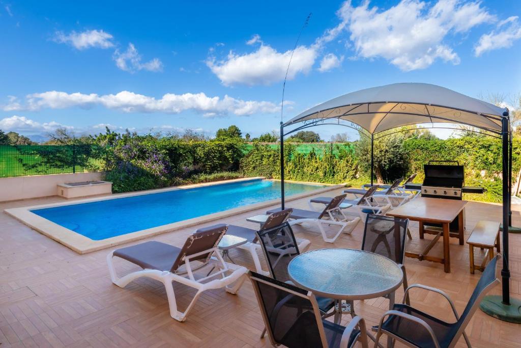 a patio with chairs and a swimming pool at Ca Na Bergues in Ariany