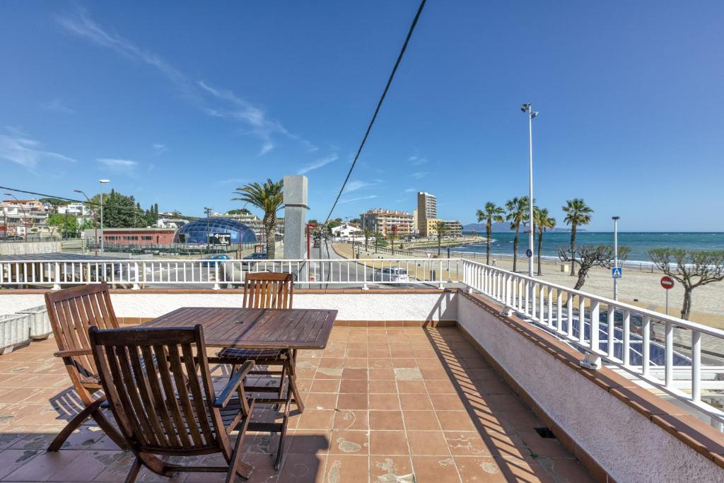 a table and chairs on a balcony with a view of the beach at Mimosa in L'Escala