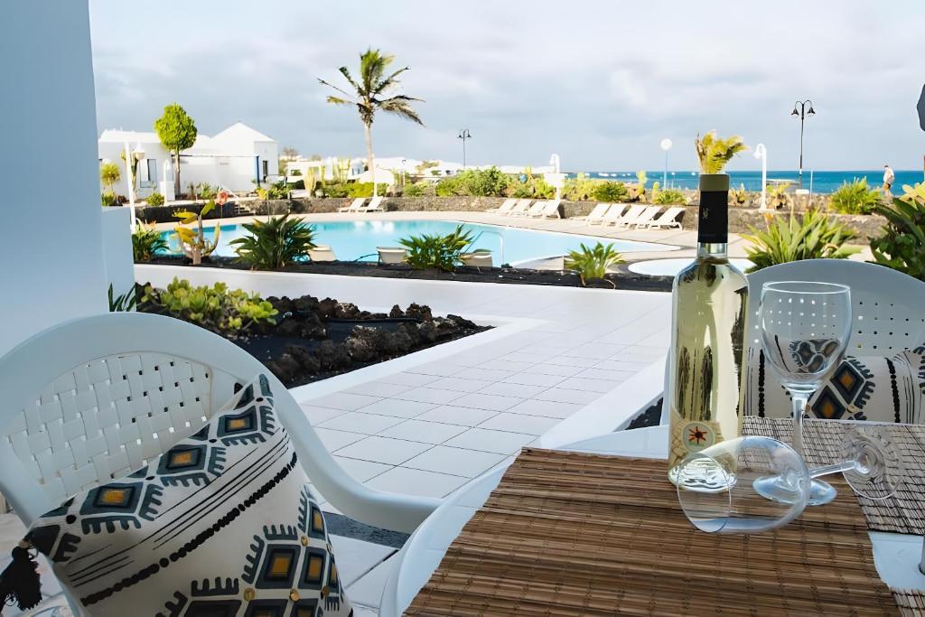 a table with a bottle of wine and a glass at Bungalow 5 - Caleta Campos in Arrieta