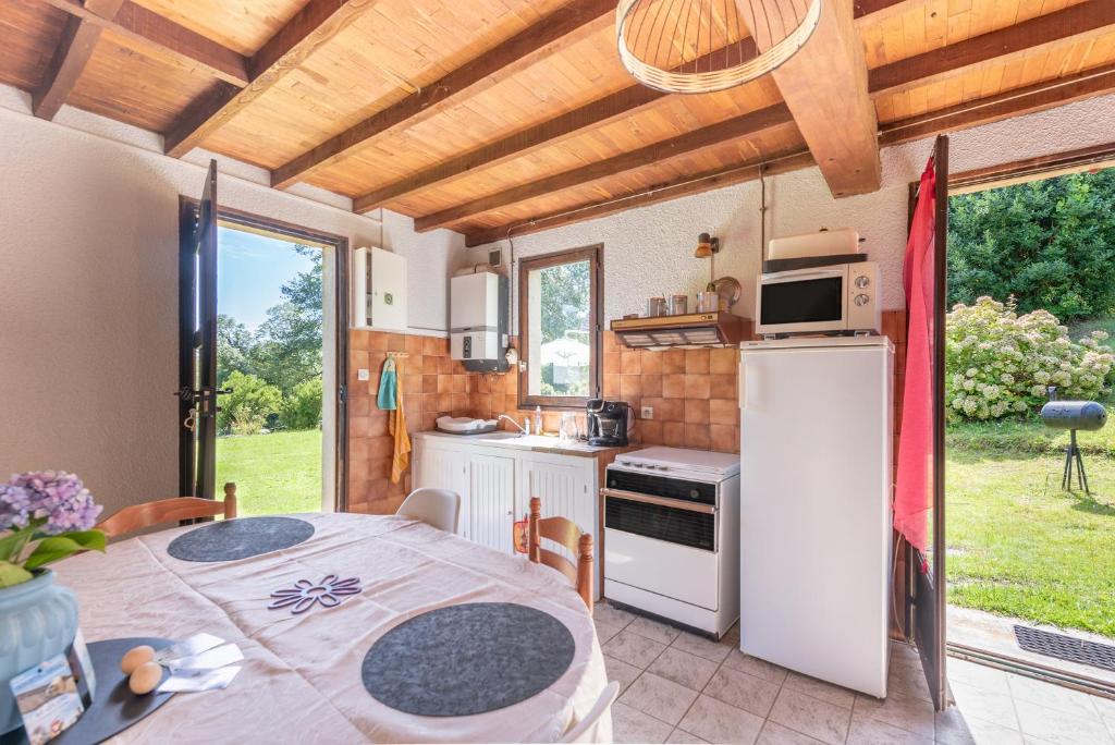 a kitchen with a table and a refrigerator and a table at Gite Anje in Peyrouse