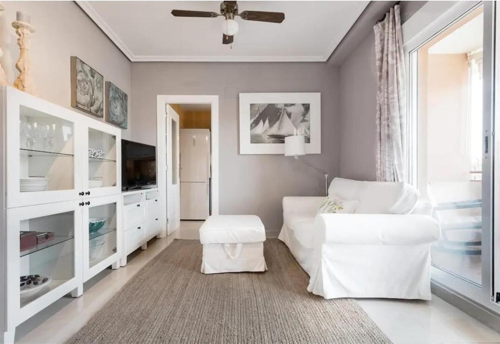 a living room with a white couch and a ceiling fan at Denia Living in Denia