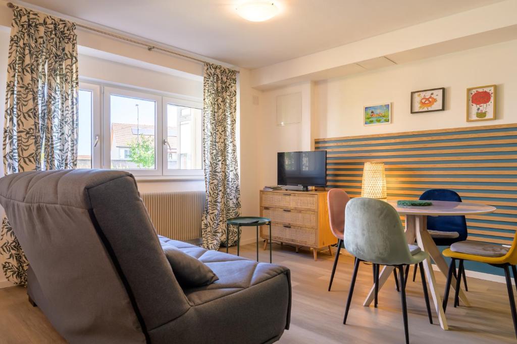 a living room with a couch and a table at Au Bretzel in Ostheim
