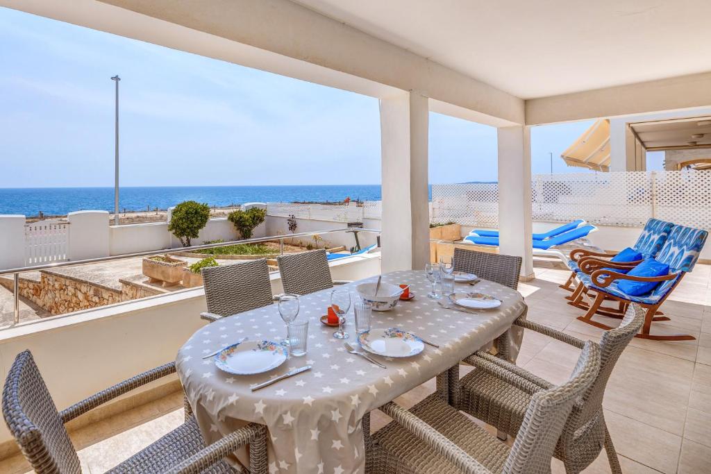 a dining room with a table and chairs and the ocean at Casa Miramar in Sa Ràpita