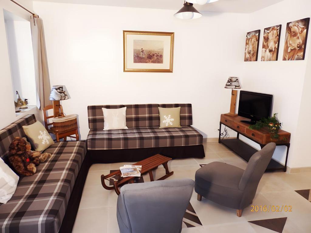 a living room with a couch and a tv at Gîte Chez Fanfoué in Orcier