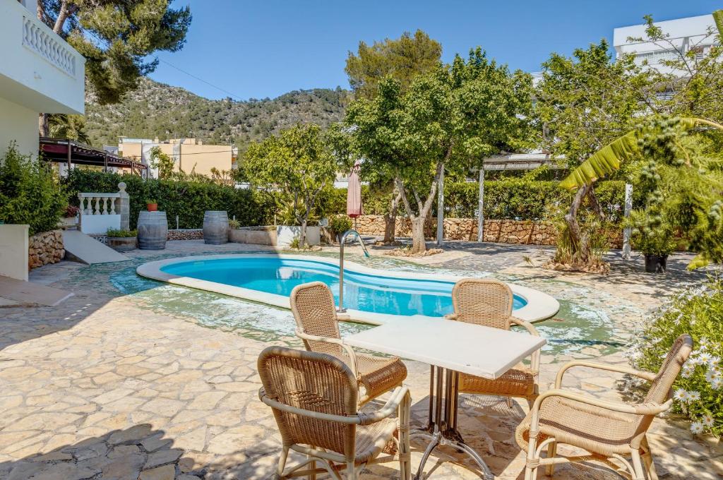 a table and chairs next to a swimming pool at Apartamento La Cabanya 2d in Canyamel
