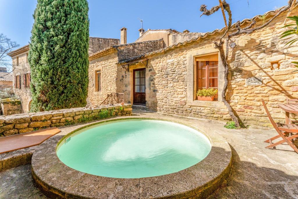 a large pool in the yard of a stone house at Au Fil Des 5 Saisons in Vers Pont du Gard