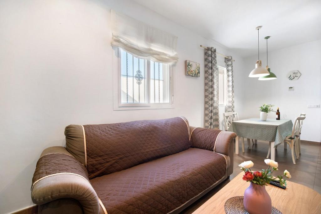 a living room with a brown couch and a table at Piso arquillo del reloj in Chiclana de la Frontera