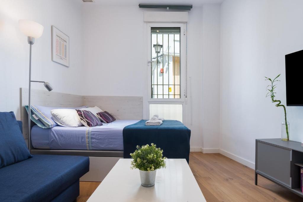 a small living room with a bed and a table at Moderno Estudio Junto Al Río in Seville