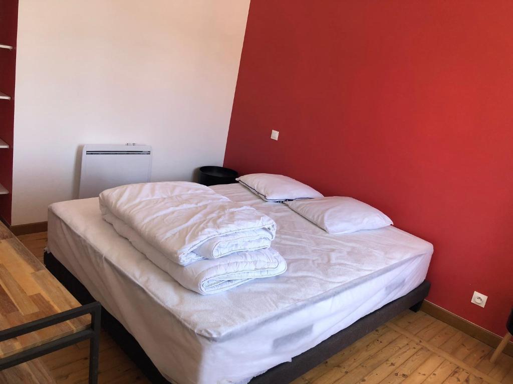 a bed with white sheets and pillows in a room at Appartement T 2 in La Bourboule