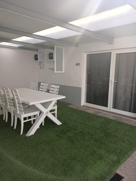 a dining room with a white table and chairs at La Corte A2 in Antigua