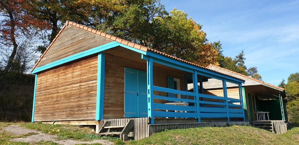 a small house with a blue door on a field at 5 Chalet Iris in Blavignac