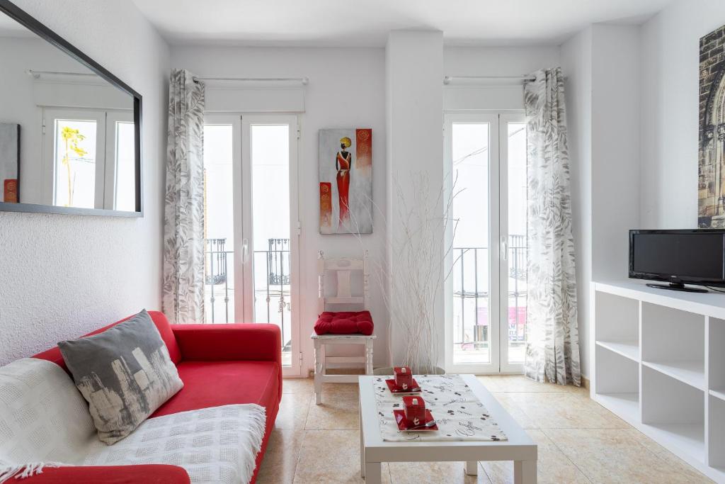 a living room with a red couch and a table at Apartamento Pintada 25 in Nerja