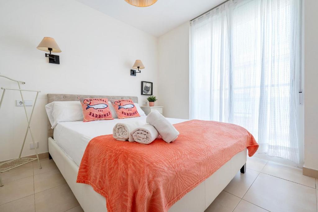 a bedroom with a bed with towels on a orange blanket at Apartamento Sf2 in L'Ametlla de Mar