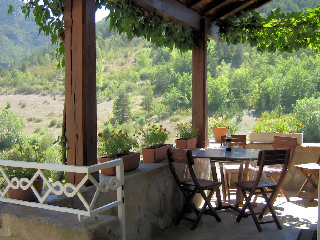 a table and chairs on a porch with a view at Gite La Lavande in Peyreleau