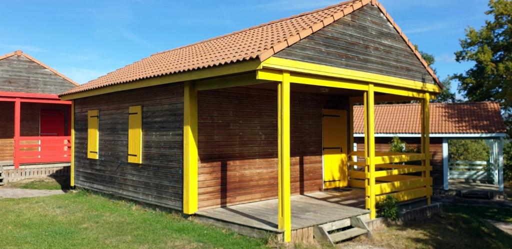 a small wooden building with yellow columns at 17 Chalet Orpin in Blavignac