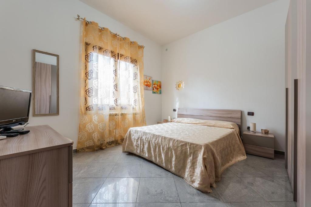 a bedroom with a bed and a flat screen tv at Red House Capoterra in Capoterra